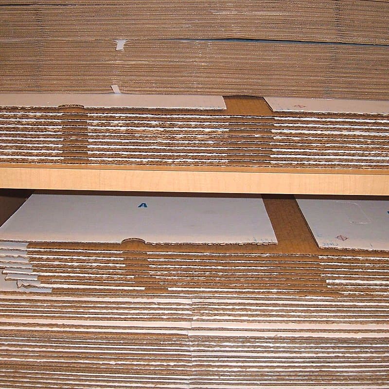 Stack of flat unassembled corrugated cartons ready to be folded into boxes