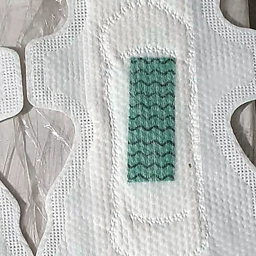Close view of a finished pad's top sheet with its embossed channels