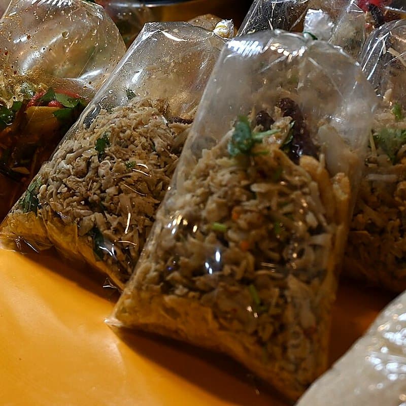 Clear plastic packets filled with dry food lined up for sale