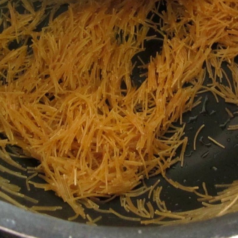 Short lengths of vermicelli being roasted golden in a pan