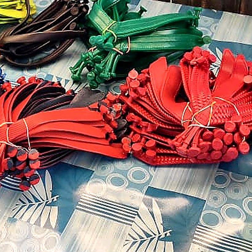 Bundles of coloured slipper straps with moulded toe plugs, tied and laid out ready for fitting