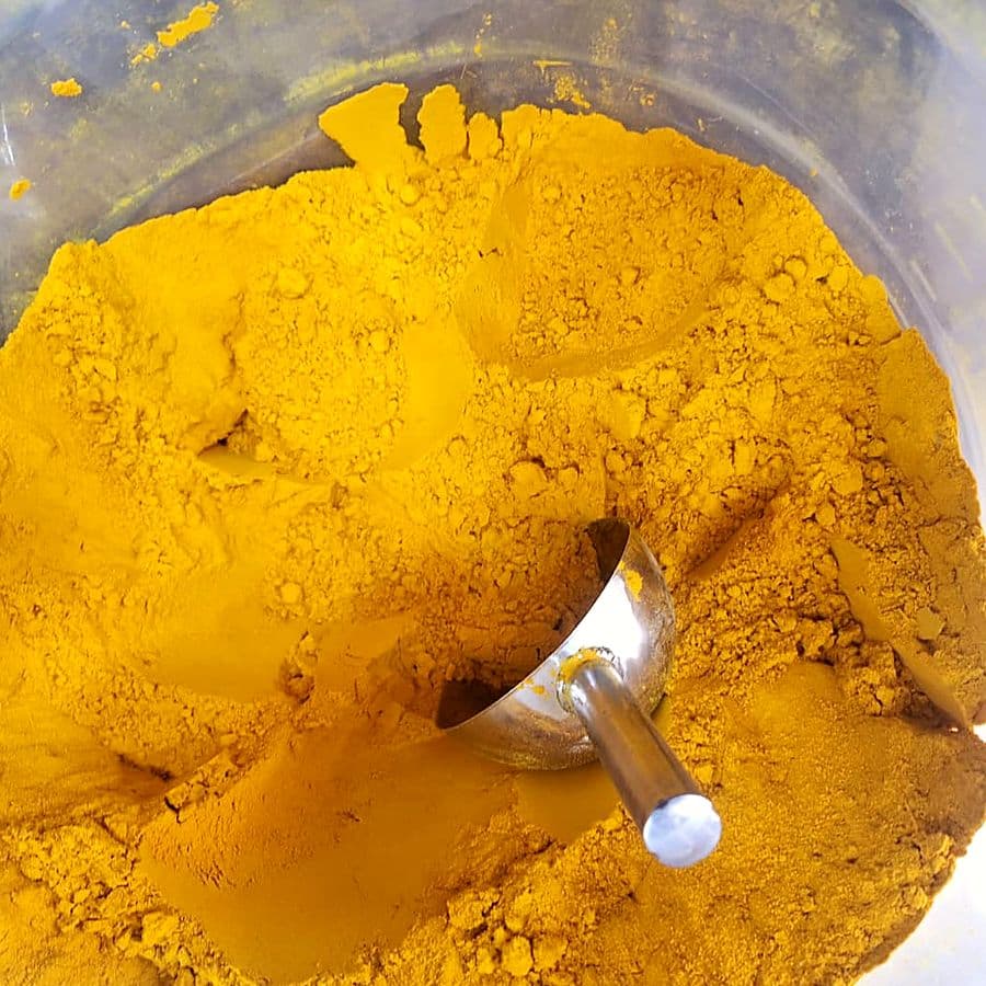 Freshly ground turmeric powder with a scoop