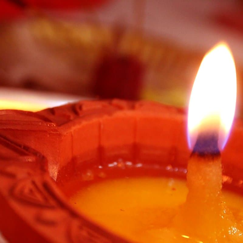 Clay diya burning with ghee and a cotton wick